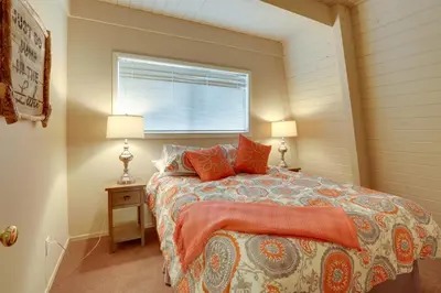 a bedroom with a bed with orange pillows and a window at Near Skiing and Hiking Carnelian Bay Cabin in Carnelian Bay