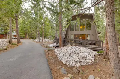 a house in the woods with a driveway at Near Skiing and Hiking Carnelian Bay Cabin in Carnelian Bay