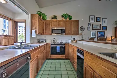 a kitchen with wooden cabinets and a sink at Spacious and Cozy Condo, 1 Block To The Village in Mammoth Lakes