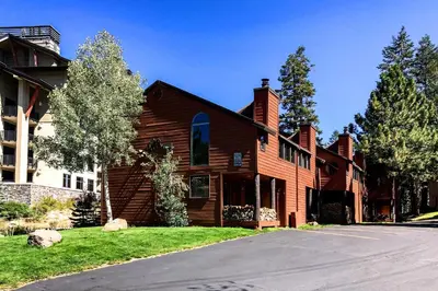a large wooden house on a street at Spacious and Cozy Condo, 1 Block To The Village in Mammoth Lakes