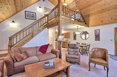 a living room with a couch and a staircase at Cabin with Hot Tub and BBQ Deck Less Than 4 Mi to Donner Lake! in Truckee