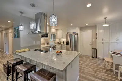 a kitchen with a large island with bar stools at Updated Sacramento Home with Grill, Patio, and Pool! in Sacramento