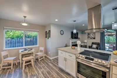 a kitchen with a stove top oven next to a table at Updated Sacramento Home with Grill, Patio, and Pool! in Sacramento