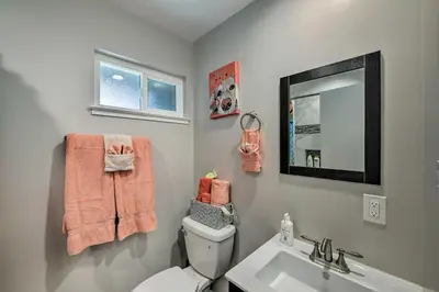 a bathroom with a toilet and a sink and a mirror at Updated Sacramento Home with Grill, Patio, and Pool! in Sacramento