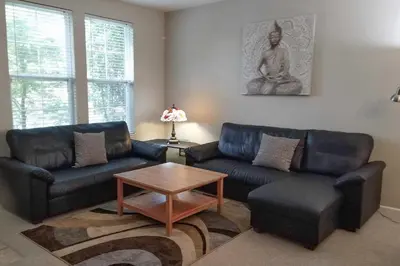 a living room with two couches and a table at Family-Friendly Tracy House with Patio and Grill! in Tracy