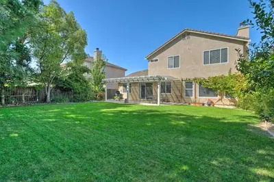 a house with a yard with a large lawn at Family-Friendly Tracy House with Patio and Grill! in Tracy