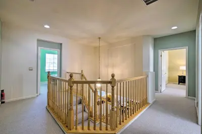 a staircase in a home with a wooden railing at Family-Friendly Tracy House with Patio and Grill! in Tracy