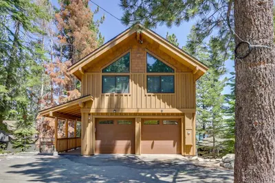 a house with a garage in a forest at Hot Tub and Lake Tahoe Views Waterfront Retreat in Tahoma