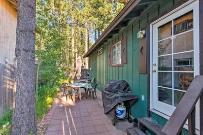 a green house with a patio and a table at Home 1 Mi to Heavenly Mtn Resort! Unwind Fireside in South Lake Tahoe