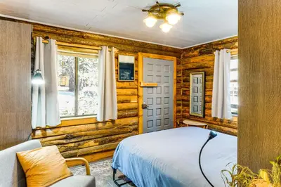 a bedroom with wooden walls and a bed and a window at Sequoia Forest Remote Retreat! Dreamtime Cabin in Ponderosa