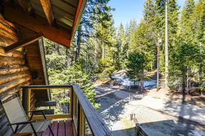 a view from the balcony of a cabin with a chair at Sequoia Forest Remote Retreat! Dreamtime Cabin in Ponderosa