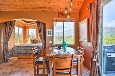 a dining room with a table and chairs and a bed at 28 Mi to Yosemite Lovely Mtn Cottage with Deck! in North Fork