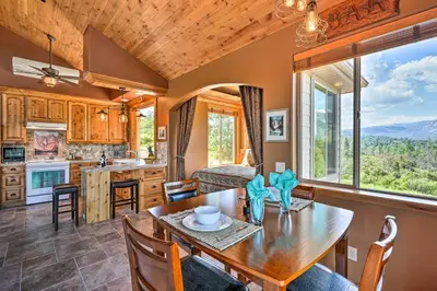 a kitchen and dining room with a table and chairs at 28 Mi to Yosemite Lovely Mtn Cottage with Deck! in North Fork