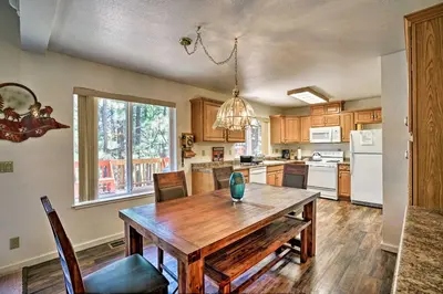 a kitchen with a wooden table and a dining room at 4 Mi to Heavenly Home with Deck in South Lake Tahoe in South Lake Tahoe