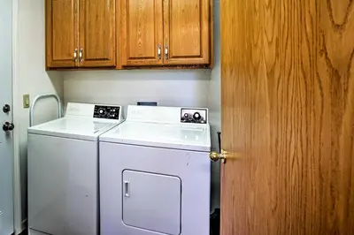 a kitchen with a white dishwasher and wooden cabinets at 4 Mi to Heavenly Home with Deck in South Lake Tahoe in South Lake Tahoe