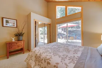 a bedroom with a bed and a door to a patio at Tahoe Donner Mountain Cabin Surrounded by Forest! in Truckee