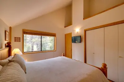 a bedroom with a large bed and a window at Truckee Home with Private Hot Tub on a Golf Course in Truckee