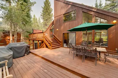 a deck with a table and chairs and an umbrella at Truckee Home with Private Hot Tub on a Golf Course in Truckee