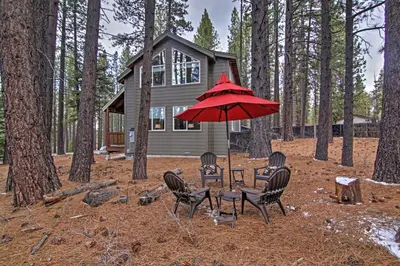 a table and chairs with a red umbrella in front of a house at 1 Mi to Mtn, 1 More to Shore! Luxury Tahoe Home in South Lake Tahoe
