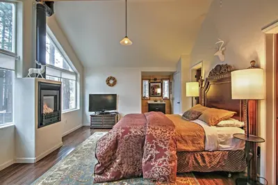 a bedroom with a large bed and a tv at 1 Mi to Mtn, 1 More to Shore! Luxury Tahoe Home in South Lake Tahoe