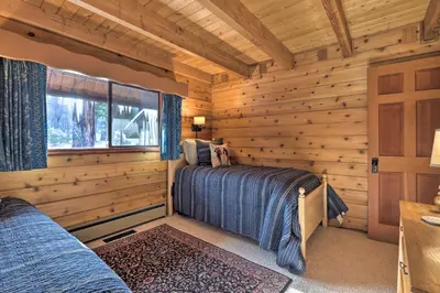 a log cabin bedroom with a bed and a window at 2 Mi to Northstar Resort Idyllic Cabin with Shuttle in Truckee