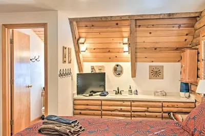 a bedroom with a bed and a tv in a room at 5 Mi to Hiking Custom Cabin with Deck in Arnold! in Arnold