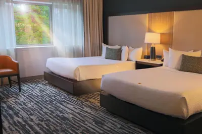 a hotel room with two beds and a window at The Hotel at Black Oak Casino Resort in Tuolumne
