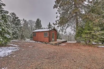 a small red cabin in the middle of a forest at Creekside Cabin 8 Mi to Kings Canyon National Park in Miramonte