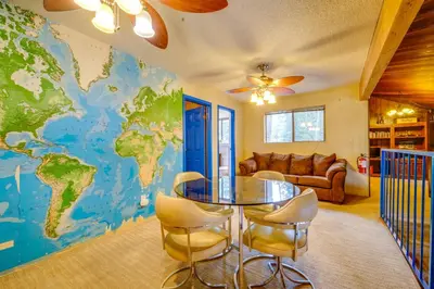 a living room with a map of the world on the wall at Waterfront Truckee Cabin on Donner Lake! in Truckee