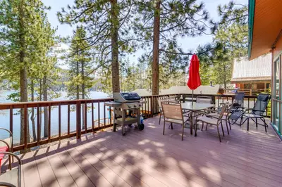 a deck with a table and chairs and a grill at Waterfront Truckee Cabin on Donner Lake! in Truckee