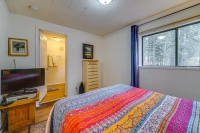 a bedroom with a bed and a flat screen tv at Waterfront Truckee Cabin on Donner Lake! in Truckee