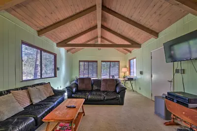 a living room with a leather couch and a flat screen tv at 6 Mi to Yosemite Natl Park 14-Acre Retreat! in Groveland