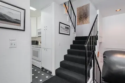 a staircase in a living room with a black stair case at Chamonix # 62 in Mammoth Lakes