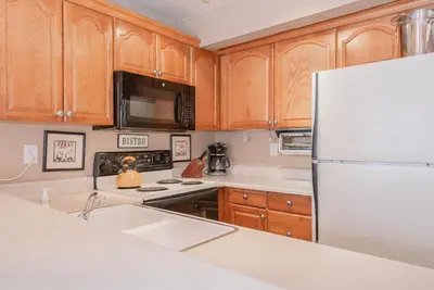 a kitchen with wooden cabinets and a white refrigerator at Bigwood W #90 in Mammoth Lakes
