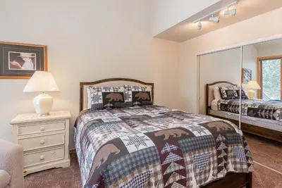 a bedroom with a bed and a dresser with a lamp at Snowcreek #856 Phase V in Mammoth Lakes