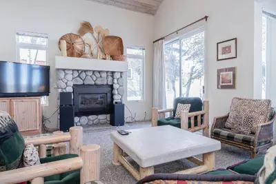 a living room with a table and a fireplace at Snowcreek - #510 Phase IV in Mammoth Lakes