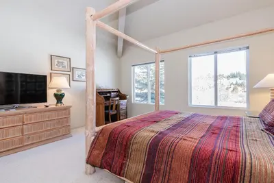 a bedroom with a canopy bed and a television at Snowcreek - #510 Phase IV in Mammoth Lakes