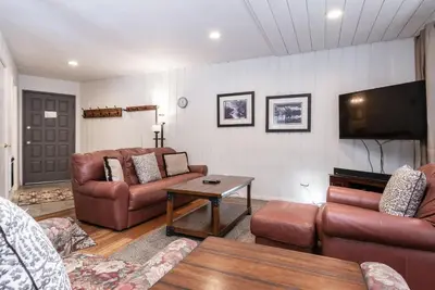 a living room with leather furniture and a flat screen tv at Sierra Park Villas N-#66 in Mammoth Lakes