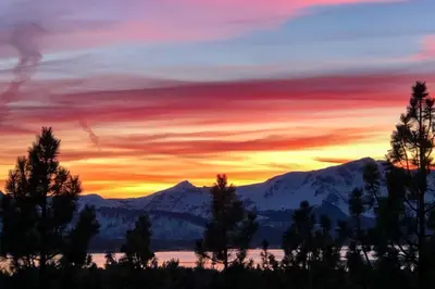 a sunset over the mountains with trees and a lake at 2 Mi to Heavenly Mountain Tahoe Retreat with Views in Stateline