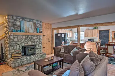 a living room with a stone fireplace in a house at 7 Mi to Heavenly Ski Resort Cozy Tahoe Cabin in South Lake Tahoe