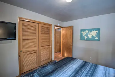 a bedroom with a bed and a tv and a closet at 7 Mi to Heavenly Ski Resort Cozy Tahoe Cabin in South Lake Tahoe