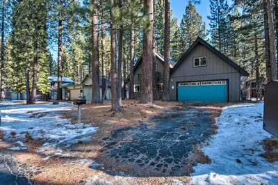 a house with a blue garage in the woods at 7 Mi to Heavenly Ski Resort Cozy Tahoe Cabin in South Lake Tahoe