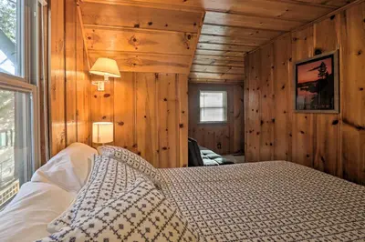 a bedroom with a bed in a room with wooden walls at Lakefront Cabin with Beach Access 8 Mi to Northstar in Tahoe Vista