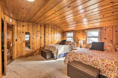 two beds in a room with wooden walls at Lakefront Cabin with Beach Access 8 Mi to Northstar in Tahoe Vista