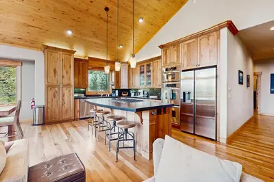 a kitchen with wooden cabinets and a large island with bar stools at Extraordinary Tahoe-Donner Modern Mountain Home in Truckee