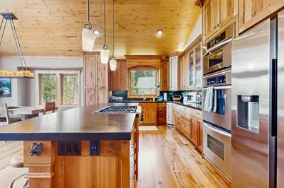 a kitchen with wooden cabinets and a large center island at Extraordinary Tahoe-Donner Modern Mountain Home in Truckee