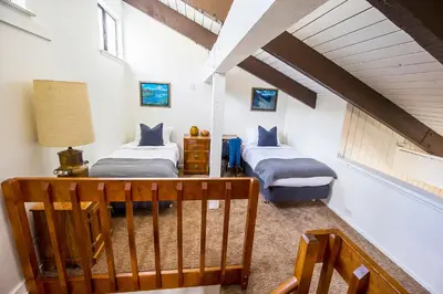 a attic room with two beds and a staircase at The Mammoth House in Mammoth Lakes
