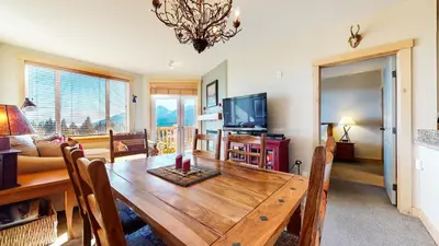a dining room and living room with a wooden table at Sunstone #209 condo in Mammoth Lakes