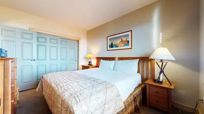a bedroom with a large bed and a door at Sunstone #209 condo in Mammoth Lakes