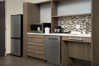 a kitchen with a refrigerator and a sink at Home2 Suites By Hilton Clovis Fresno Airport in Clovis